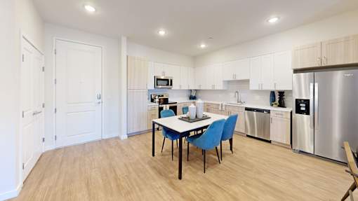 A kitchen with a table and chairs in the middle of the room.