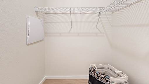 A white wall with a white shelf and a black and white bag on the floor.