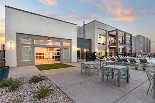 A modern building with a patio and chairs.