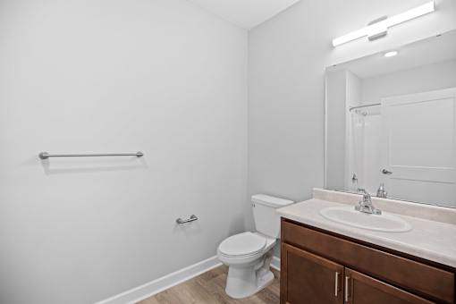 A white bathroom with a toilet, sink, and mirror.