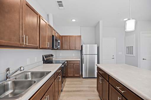A kitchen with brown cabinets and a stainless steel refrigerator.