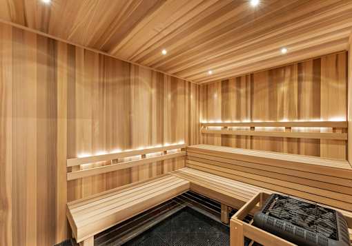 A wooden sauna with benches and lights.