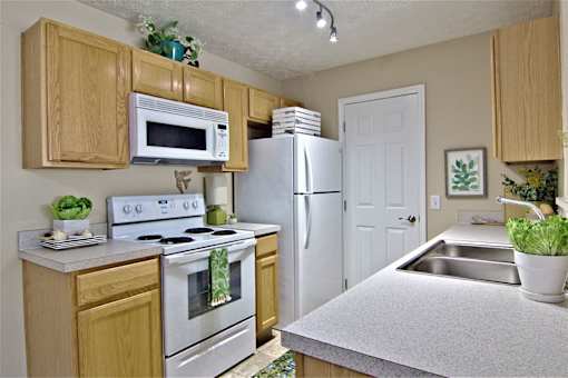 A kitchen with wooden cabinets and a white refrigerator.
