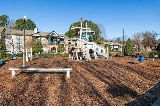 A playground with a slide and a wooden bench.