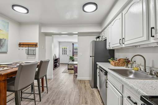 A kitchen with a dining table and chairs.