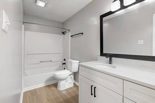 A white bathroom with a toilet, sink, and bathtub.