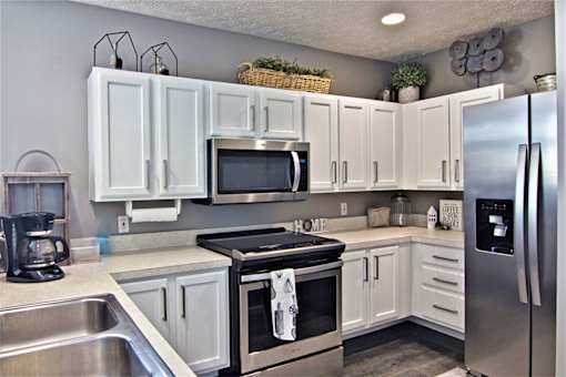 A kitchen with white cabinets and a black stove top.