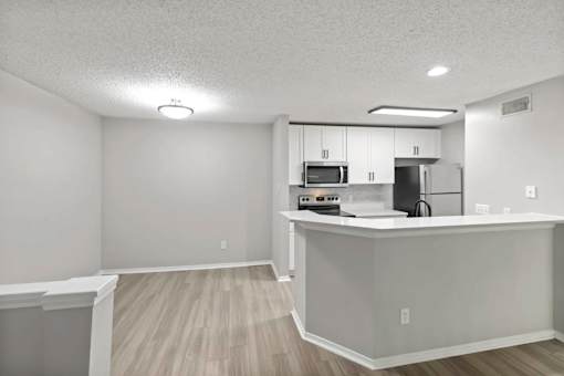 A kitchen with white cabinets and a white countertop.