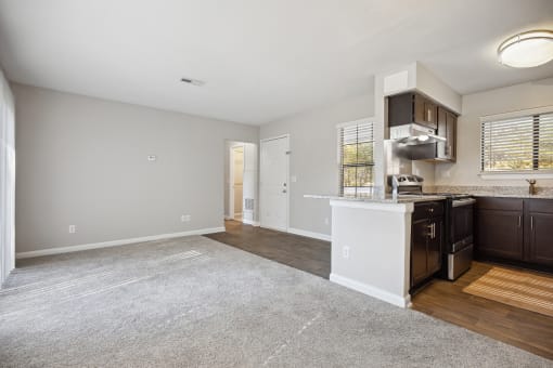 an empty kitchen and living room with a kitchen counter top and