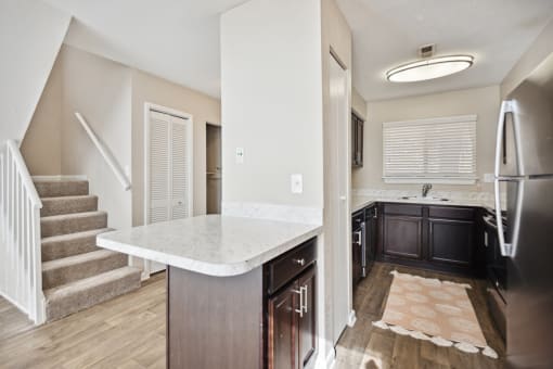 a kitchen with a sink and a counter top in a new home