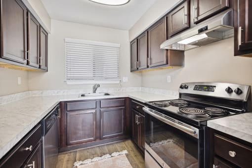 the kitchen of a home with dark wood cabinets and white countertops