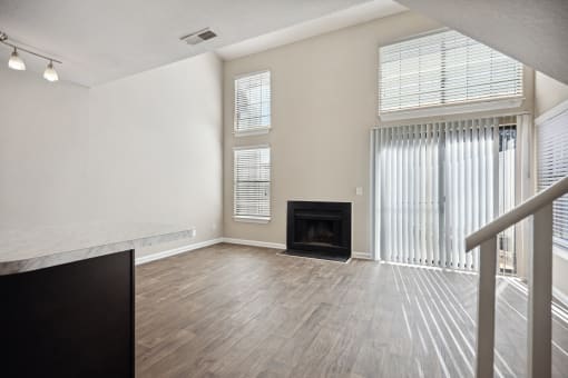 the living room of an apartment with a fireplace and wood flooring