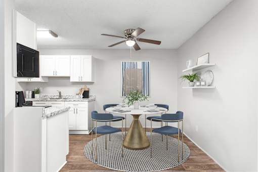 A kitchen with a dining table and chairs.