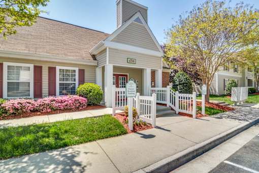 A small building with a white picket fence in front of it.