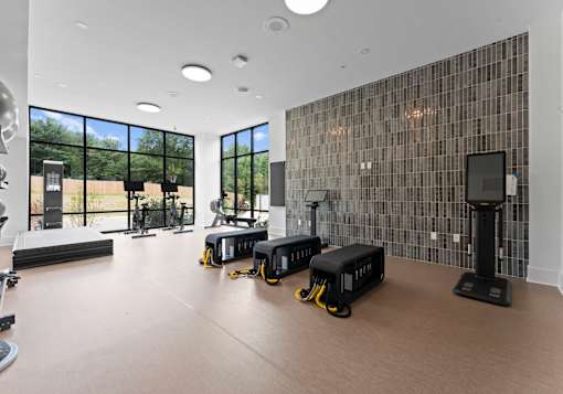 A gym with treadmills, elliptical machines, and other exercise equipment.