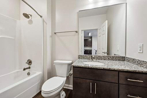 A white bathroom with a toilet, sink, and bathtub.