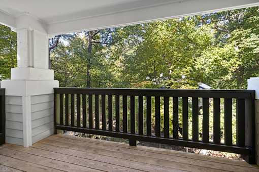 A balcony with a black railing and a white column.