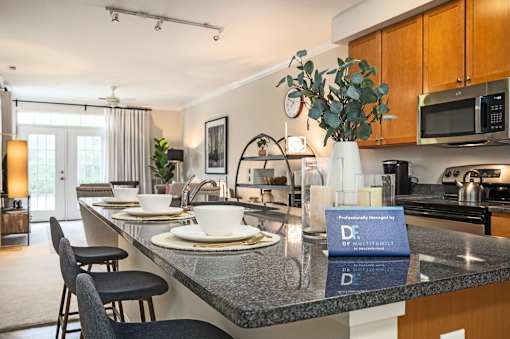 A kitchen with a black counter top and a sign that says "Professionally Installed by DF Militant.".