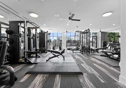 A spacious gym with a variety of equipment and a large mirror on the wall.