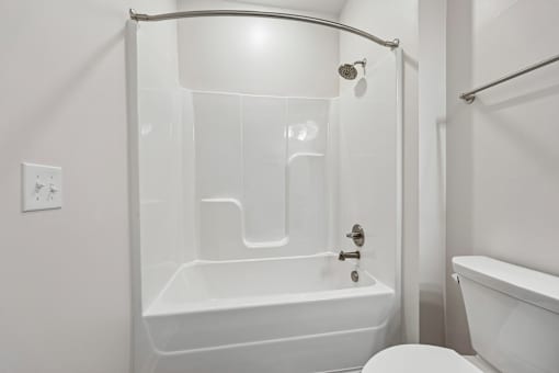 A white bathroom with a tub, toilet, and sink.