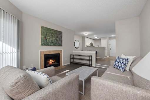 A living room with a fireplace and a painting on the wall.