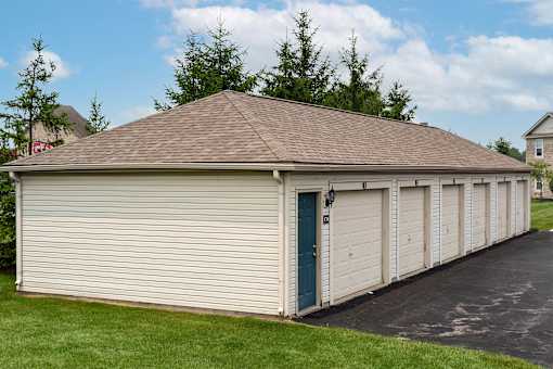 A long building with a blue door and a brown roof.