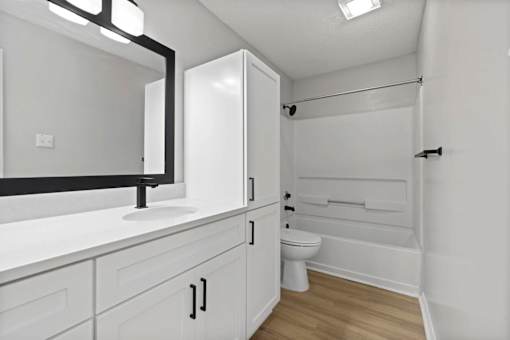 A white bathroom with a toilet, sink, and bathtub.