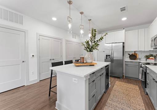 A kitchen with a white island and a refrigerator.