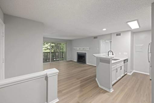 A kitchen with white cabinets and a wooden floor.