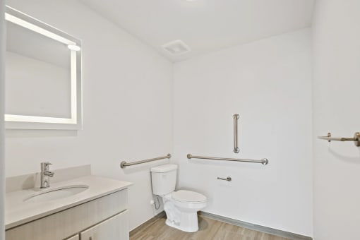 a bathroom with a toilet and a sink and a mirrorat Metropolis Apartments, Glen Allen, VA 23060