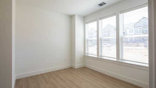 a bedroom with white walls and a wooden floor at Ainsworth, Richmond, Virginia