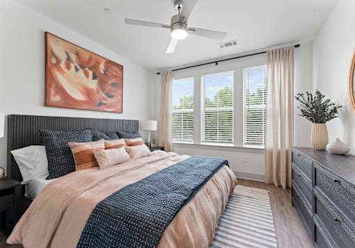 A bedroom with a large bed and a ceiling fan.
