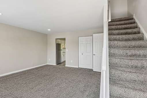 A room with a staircase leading to another room.