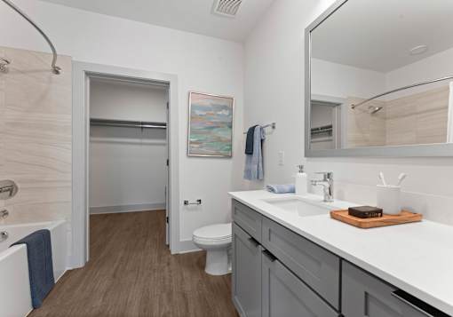 A bathroom with a white sink, toilet, and a mirror.