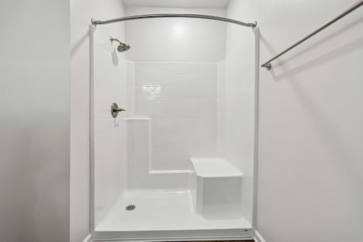 A white bathroom with a glass shower stall.