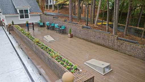 A patio with a hot tub and chairs.