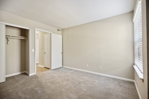 an empty living room with a door to a closet