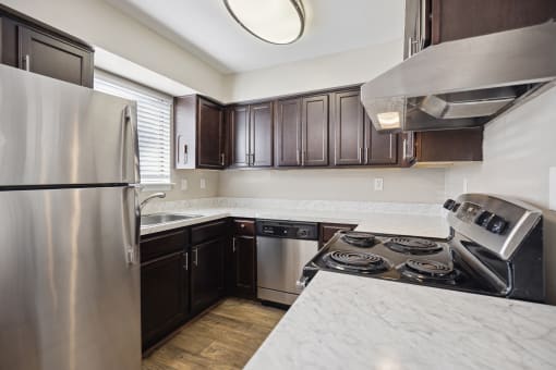 an updated kitchen with stainless steel appliances and marble counter tops