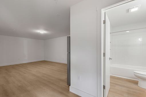 A white bathroom with a toilet and a glass shower door.