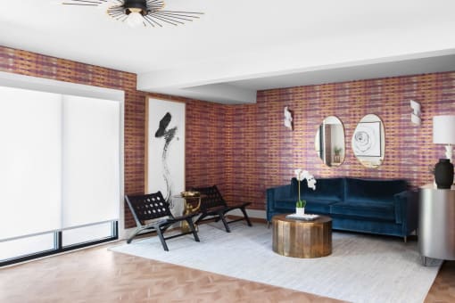 a living room with a blue couch and a brick wall