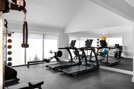 a gym with treadmills and other workout equipment in a home