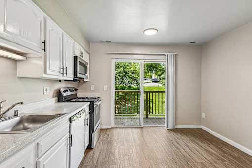 A kitchen with a sink, stove, and microwave.