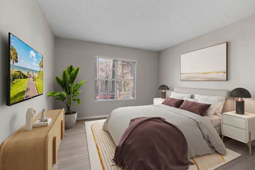 A modern bedroom with a large bed, a TV on the wall, and a potted plant.