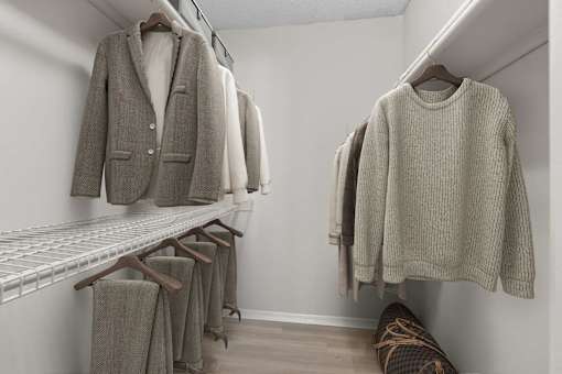 A row of clothes hanging on a rack in a room.