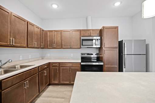 A kitchen with brown cabinets and stainless steel appliances.