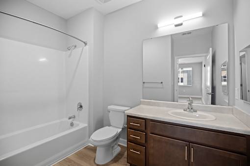 A white bathroom with a toilet, sink, and bathtub.