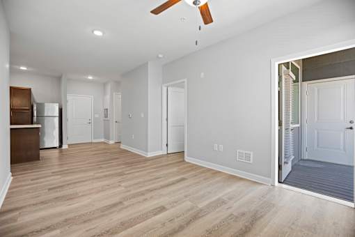 A spacious room with a ceiling fan and lighting.