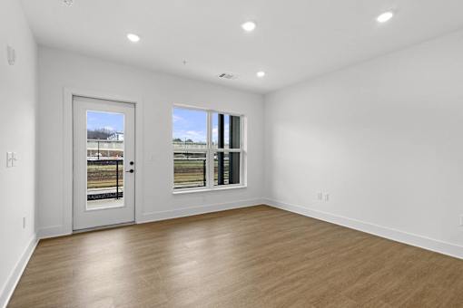 A room with a white wall and a wooden floor.