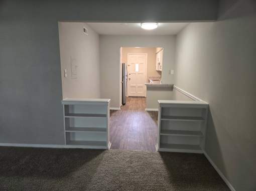 A room with a grey carpet and a white door.