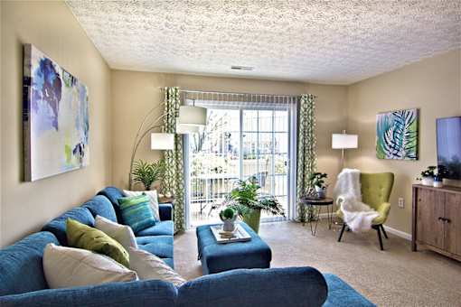 A living room with a blue couch and a green chair.